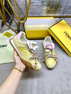 FENDI Wave Pulse繫帶低幫運動鞋。黃色緞面材質，飾有褶襉和同色系絨面革嵌飾。淡紫色皮革後跟鞋領。鞋舌為可拆卸摺疊式設計，飾有立體同色花冠飾片。同色系彈力鞋帶搭配拼色管狀鞋帶，點綴淡紫色珠飾及飾有金色FF圖案的立方元素。鞋側與鞋