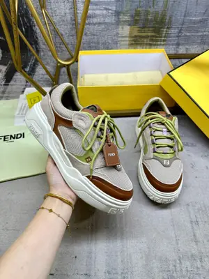 FENDI Force繫帶低幫鞋。米色網眼布材質，採用棕色和綠色絨面革和皮革軟墊和嵌飾設計元素。飾有嵌邊和底部注塑元素。側面細節帶有注塑FF。輕質厚實米色EVA鞋底，鞋頭及鞋跟飾有FF圖案。綠色鞋帶飾有可拆卸全粒麵皮革掛飾，帶FENDI R