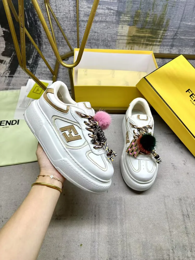 FENDI Match繫帶運動鞋。白色面料，帶米色細節。側邊飾有撞色皮革FF貼花，白色、米色和棕色登山鞋帶。橡膠厚鞋底，後跟處飾有超大凸紋壓花FENDI字樣。鞋舌上飾有金屬環掛飾：右鞋上飾有帶撞色貂毛細節和金色金屬FF圖案手鍊的編繩小玩偶。