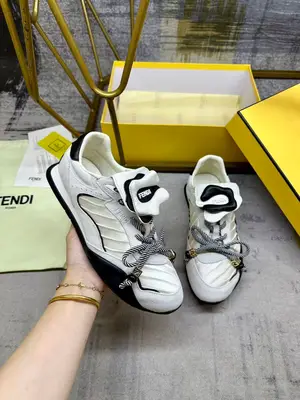 FENDI Wave Pulse繫帶低幫運動鞋。米白色緞面材質，飾有褶襉和同色系絨面料嵌飾。黑色皮料後跟鞋領。鞋舌為可拆卸摺疊式設計，飾有立體同色花冠飾片。彈力鞋帶搭配拼色管狀鞋帶，飾有黑色珠飾和金色FF圖案立方元素。鞋側與鞋舌飾有立體橡膠