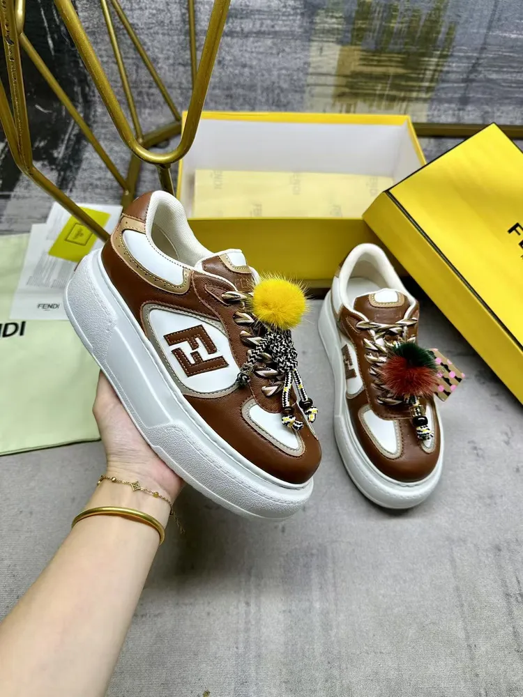 FENDI Match繫帶運動鞋。棕色面料，帶米色細節。側邊飾有撞色皮革FF貼花，白色、米色和棕色登山鞋帶。橡膠厚鞋底，後跟處飾有超大凸紋壓花FENDI字樣。鞋舌上飾有金屬環掛飾：右鞋上飾有帶撞色貂毛細節和金色金屬FF圖案手鍊的編繩小玩偶。