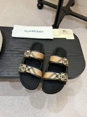 💰編織面P640元！ Burberry2025爆款拖鞋出爐，選用柔軟反絨面革面料打造，於義大利工坊精製而成。融入格紋圖案壓花，搭配壓紋鞋底，其上點綴典藏品牌徽標。設有可調式 B 字型釦環束帶，裝飾提花精紡的標誌性沙色 Burberry 格
