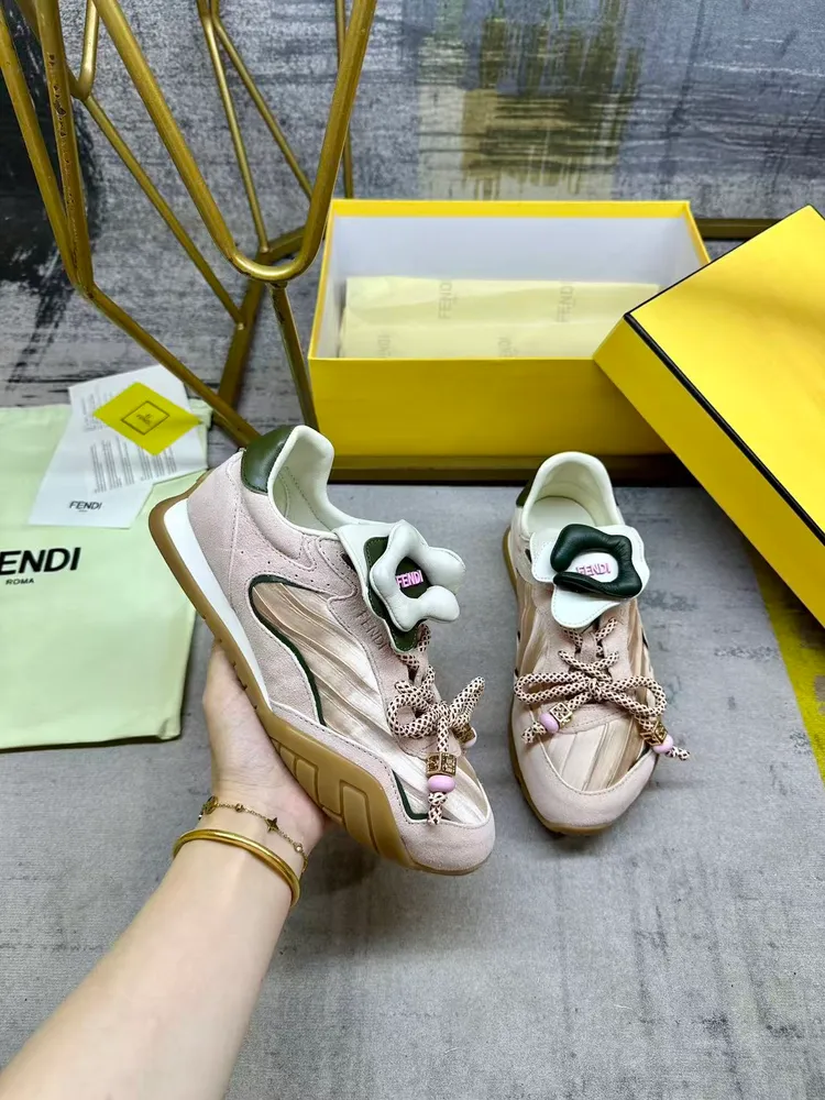 FENDI Wave Pulse繫帶低幫運動鞋。粉紅色緞面材質，飾有褶襉和同色系絨面革嵌飾。綠色皮革後跟鞋領。鞋舌為可拆卸摺疊式設計，飾有立體同色花冠飾片。彈力鞋帶搭配拼色管狀鞋帶，飾有粉紅色珠飾和金色FF圖案立方元素。鞋側與鞋舌飾有立體橡