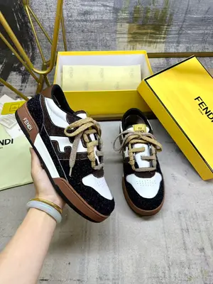 FENDI Match一腳蹬運動鞋。白色牛皮革材質，側面採用炭灰色和深棕色長毛剖層皮革細節呈現FF圖案。飾有棕色毛圈鞋帶，編織成FF圖案。內部鬆緊帶設計方便穿脫。帶棕色減震材質的橡膠包覆鞋底。女35-40碼P670，男38-45碼