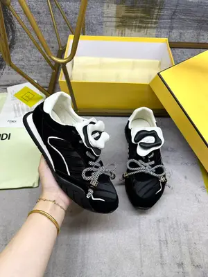 FENDI Wave Pulse繫帶低幫運動鞋。黑色緞面材質，飾有褶襉和同色系絨面料嵌飾。白色皮料後跟鞋領。鞋舌為可拆卸摺疊式設計，飾有立體同色花冠飾片。彈力鞋帶搭配拼色管狀鞋帶，飾有黑色珠飾和金色FF圖案立方元素。鞋側與鞋舌飾有立體橡膠標