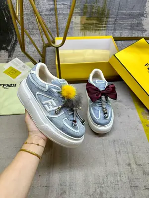 FENDI Match繫帶運動鞋。淺藍色牛仔面料效果印花材質。側面飾有白色皮革FF貼花，配同色系登山鞋帶。橡膠厚鞋底，後跟處飾有超大凸紋FENDI字樣。鞋舌上飾有金屬環掛飾：右鞋上飾有帶藍色和黃色貂皮細節和金色金屬FF圖案手鍊的編繩小玩偶。