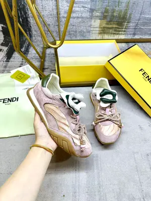 FENDI Wave Pulse繫帶低幫運動鞋。粉紅色緞面材質，飾有褶襉和同色系絨面革嵌飾。綠色皮革後跟鞋領。鞋舌為可拆卸摺疊式設計，飾有立體同色花冠飾片。彈力鞋帶搭配拼色管狀鞋帶，飾有粉紅色珠飾和金色FF圖案立方元素。鞋側與鞋舌飾有立體橡